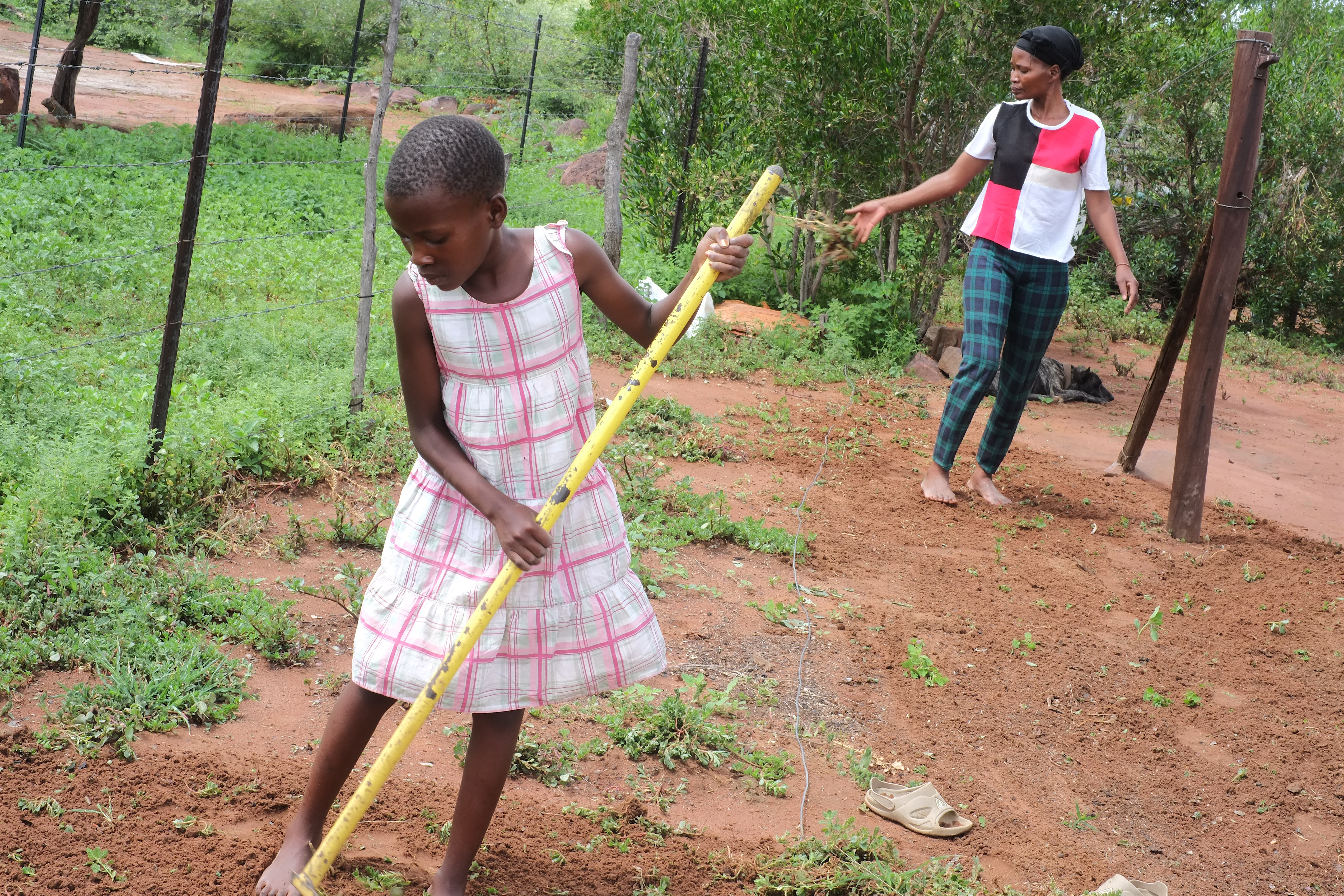 Gaolatlhe Kalanke and her daughter working the land outside their home. Photo Credit: UNAIDS