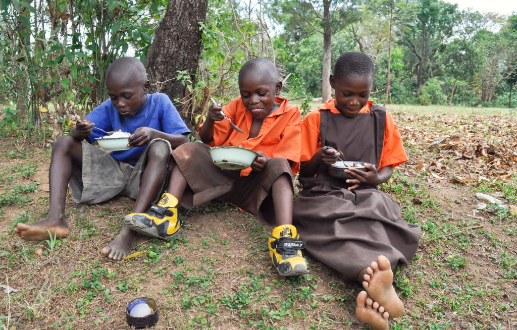 Shalene’s children (from left) Laban Wanyonyi, Mark Wekesa, and Getrine Nasimiyu eat a lunch of rice and beans at home in Luucho.