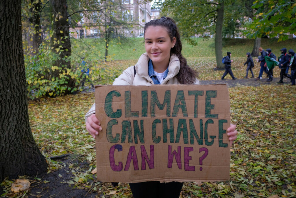 ONE Activist carrying a placard that reads Climate can change can we? 