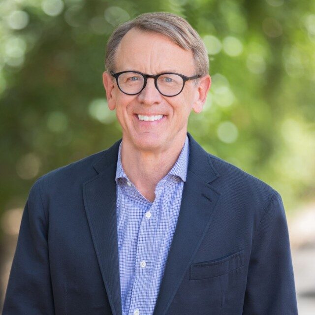 portrait of Joh Doerr against blurry leafy background