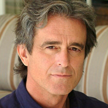 headshot of Bobby Shriver with striped couch in the background