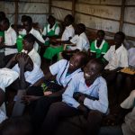Guor Path, 14, and Miakol Kiir, 14, attend class with other pupils at Yida Refugee Primary School, in Yida, South Sudan. The boys catch fish to raise money for school fees and books.

